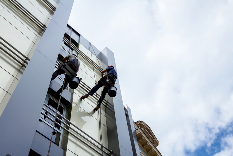 Two,Industrial,Climbers,Are,Washing,,Cleaning,Facade,Of,A,Modern